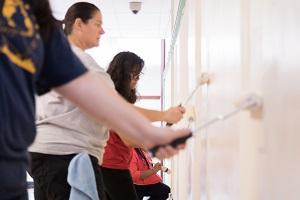 Baxter employees painting a wall